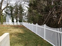 <b>5' high white pvc picket fence in contemporary style with pointed pickets and new england post caps with a concave pattern</b>
